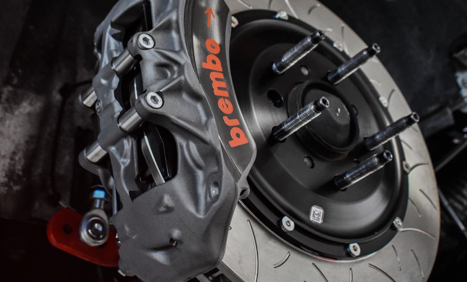 High-performance brake caliper and slotted rotor assembly